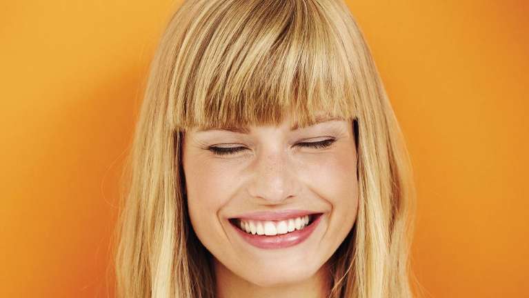 girl smiling after teeth whitening treatments in Aurora