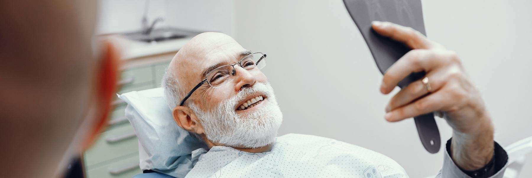 man admiring his smile at the dentist in aurora co